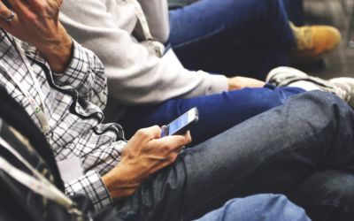 Two men sitting with their cell phones in their hands